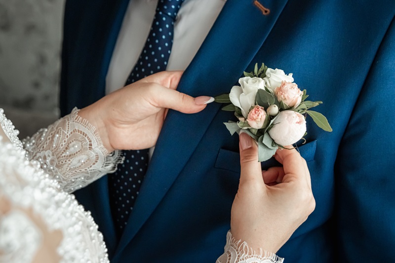 新郎にブートニアをつける新婦