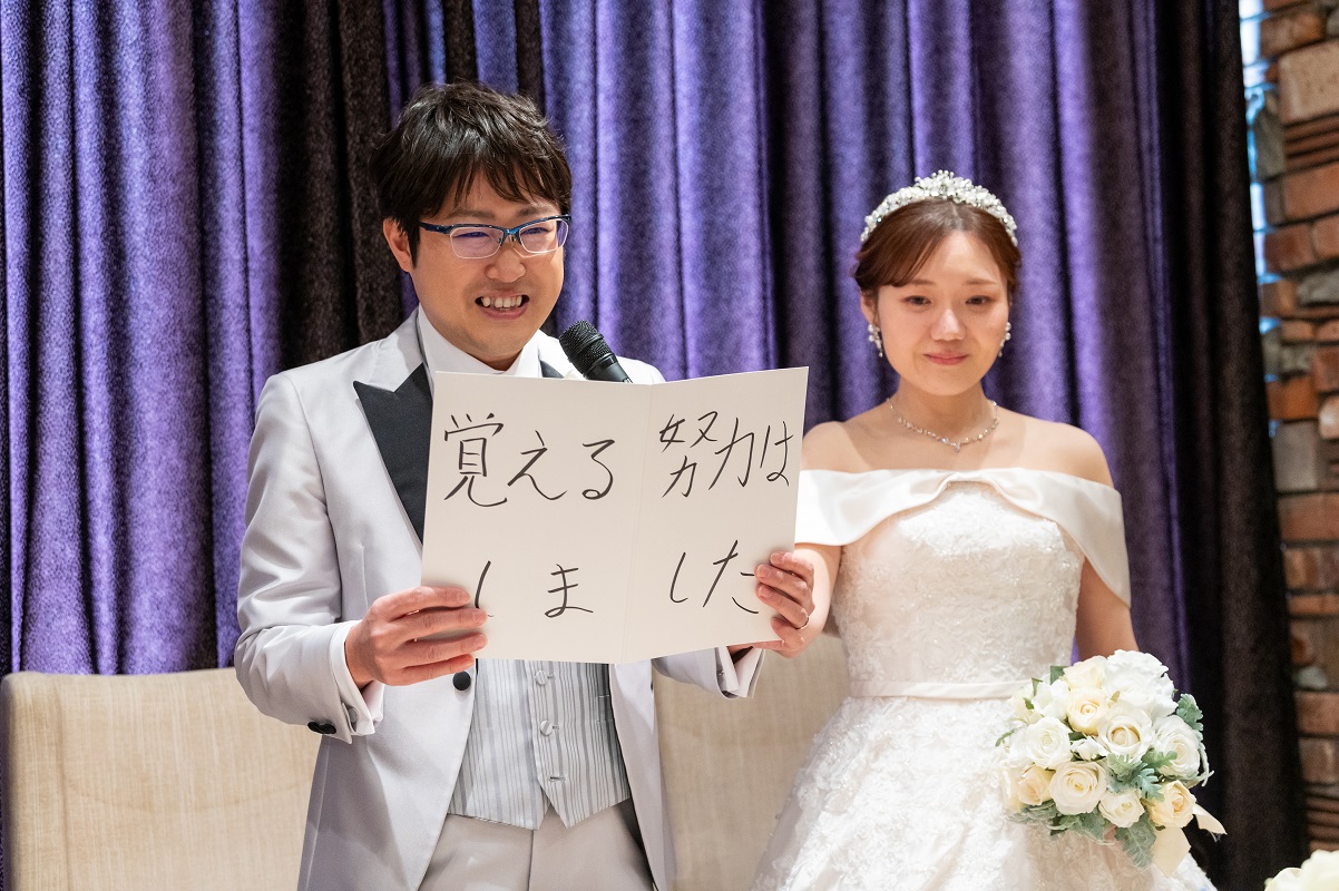 ウェルカムスピーチのカンペを持つ新郎