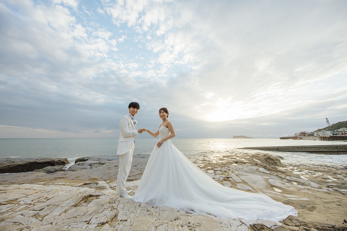 海をバックに手を取り合う新郎新婦